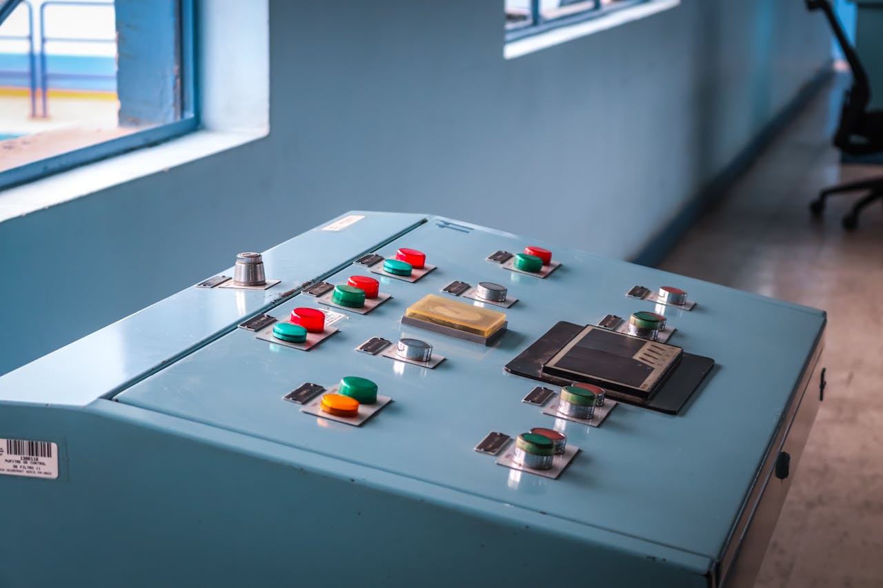 creative-02 Close-up of an industrial control panel with colorful buttons in a factory setting.